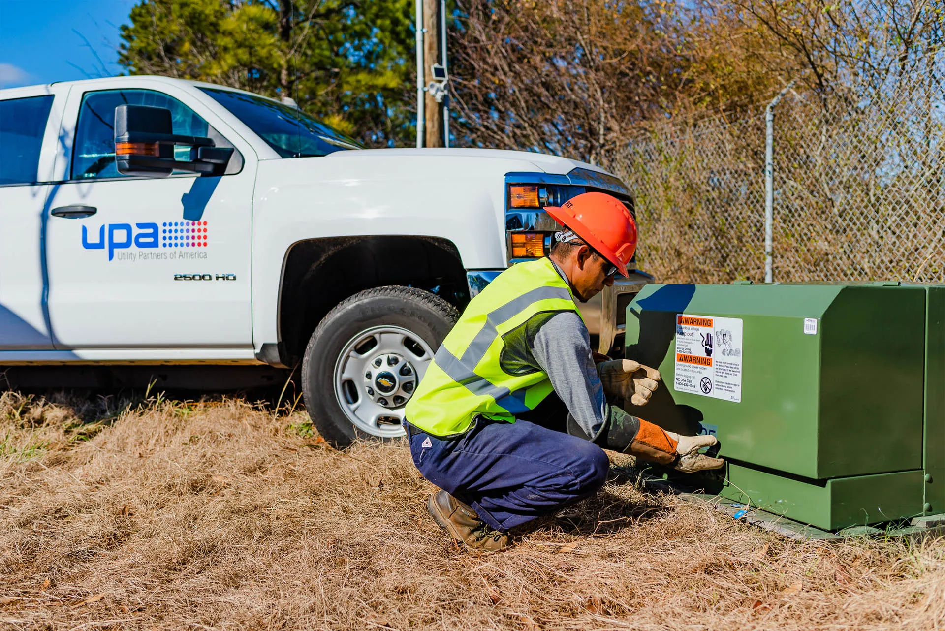 UPA technician opening a distribution transformer cabinet beside a service truck