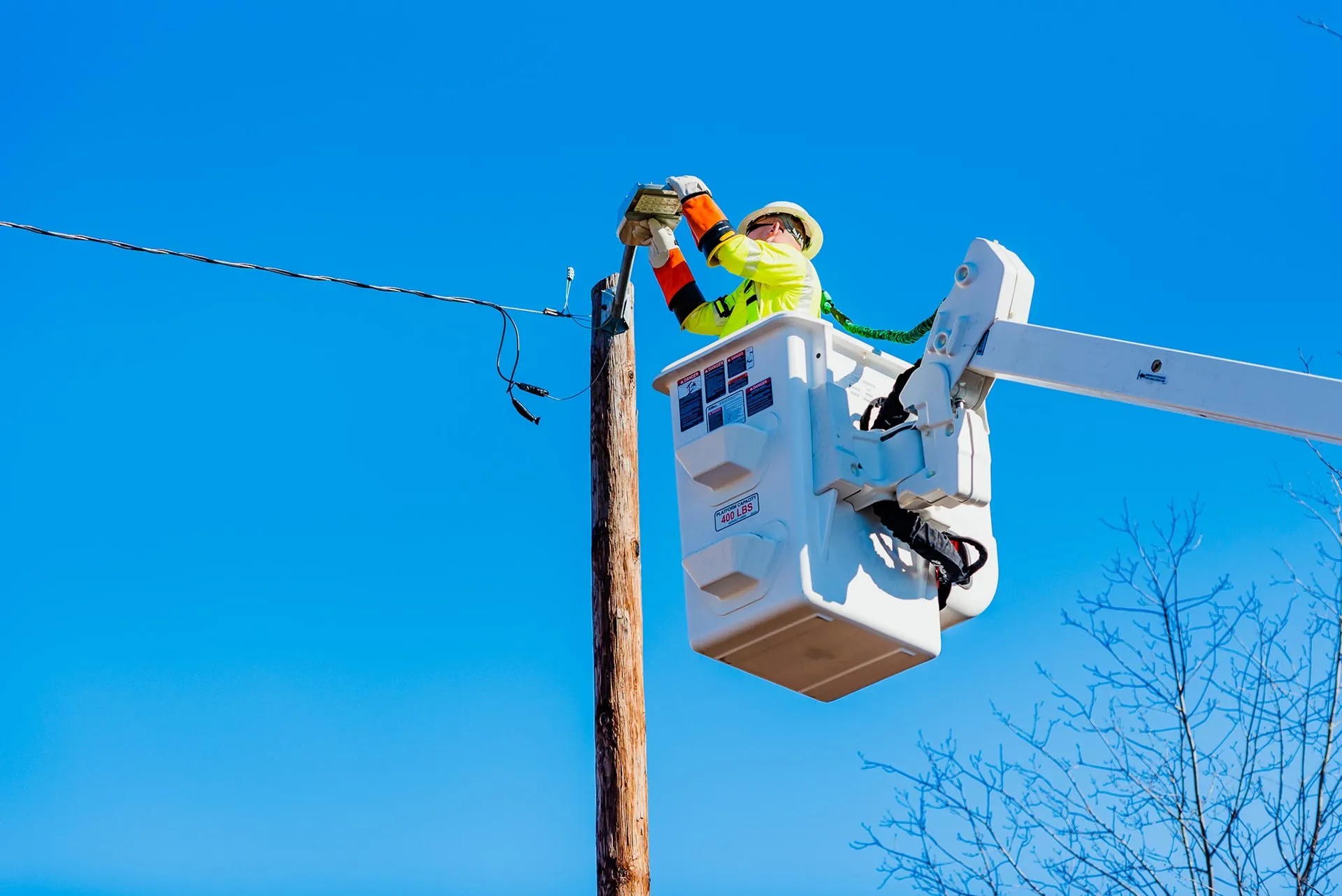 Technician in a bucket truck working on a pole-mounted light