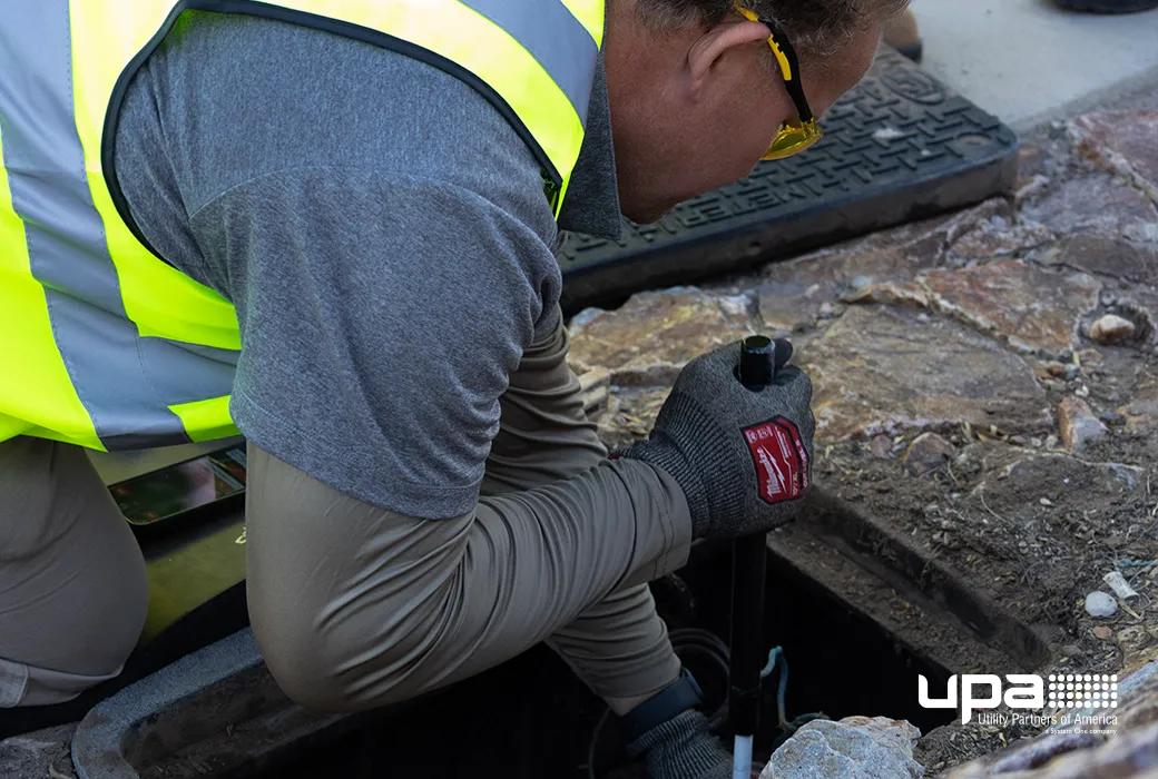 A technician inspecting a meter in an open water meter box