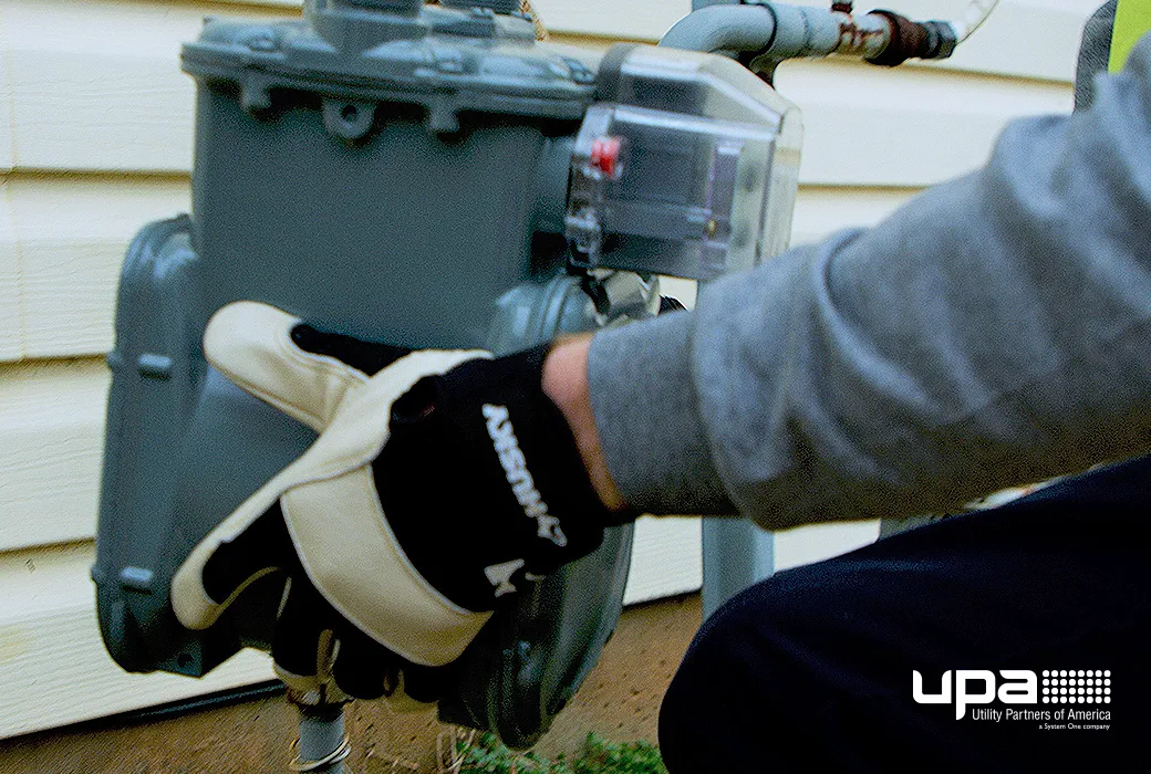A gloved technician replacing a residential gas meter